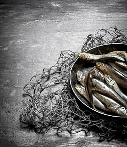鱼网上一个碗里的斑点黑木本底木制的高清图片素材