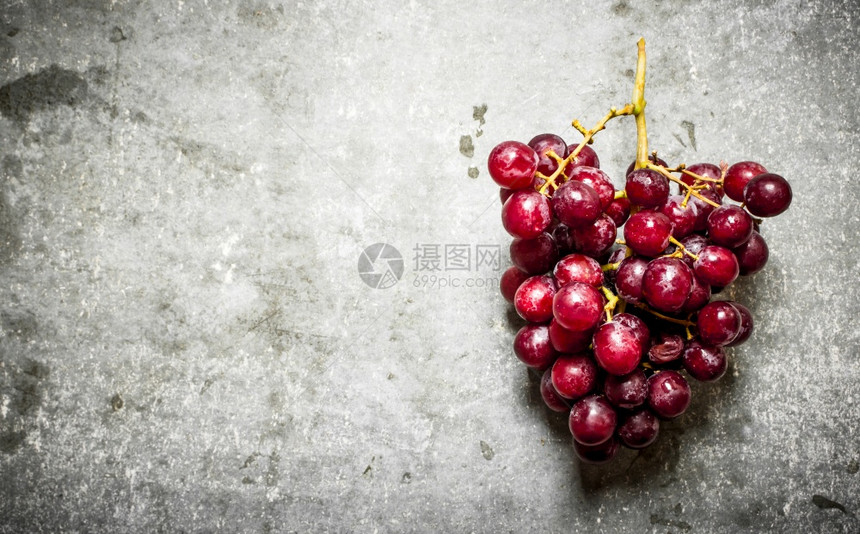 红葡萄的枝子在石板上图片