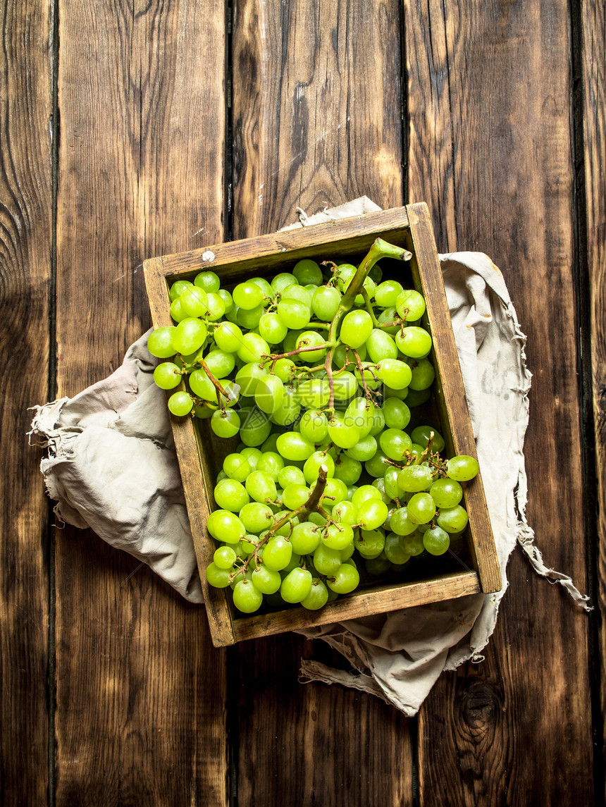 白葡萄在一个旧盒子里木制背景图片