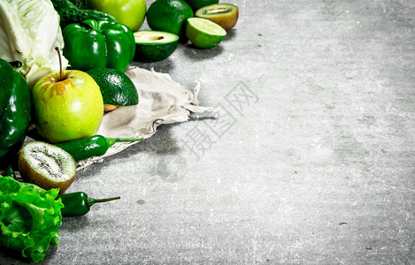 绿色食物水果和蔬菜石头桌上的绿色水果和蔬菜图片