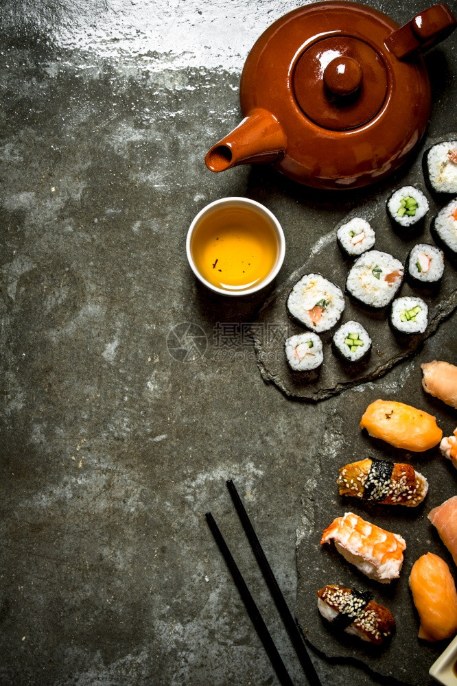 日式食品寿司卷和茶杯在石桌上图片