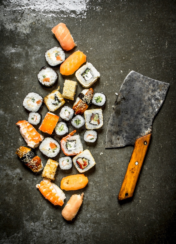 各种日本寿司卷和切片在石板上图片