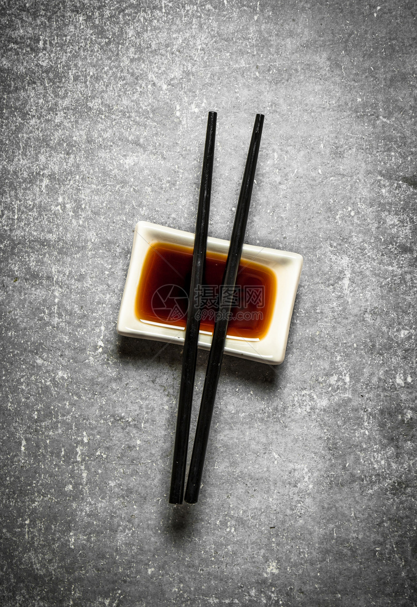 酱油和寿司的筷子在石板桌上图片