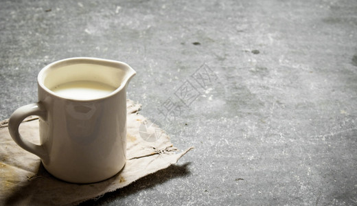 杯子里的新鲜牛奶在石板上图片