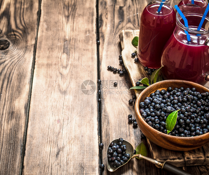 蓝莓新鲜果汁放在木制桌子上蓝莓汁放在木制桌子上图片