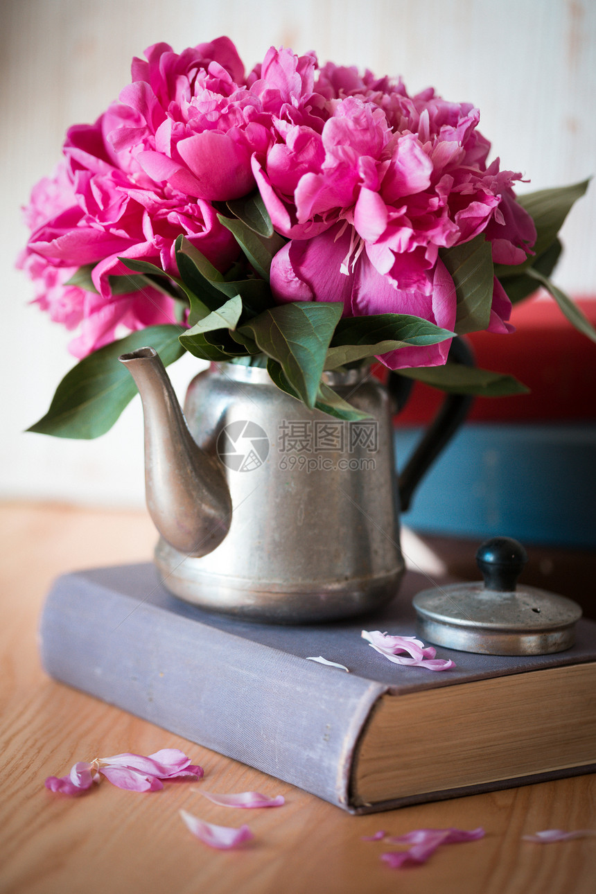 一个古老的金属茶壶里美丽的粉色红小脸孔站在一本书上的茶叶智能手机的壁纸图片