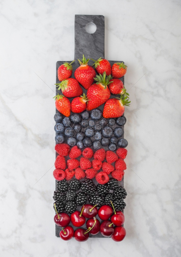 黑大理石板上色背景的黑莓草蓝黑和樱桃图片