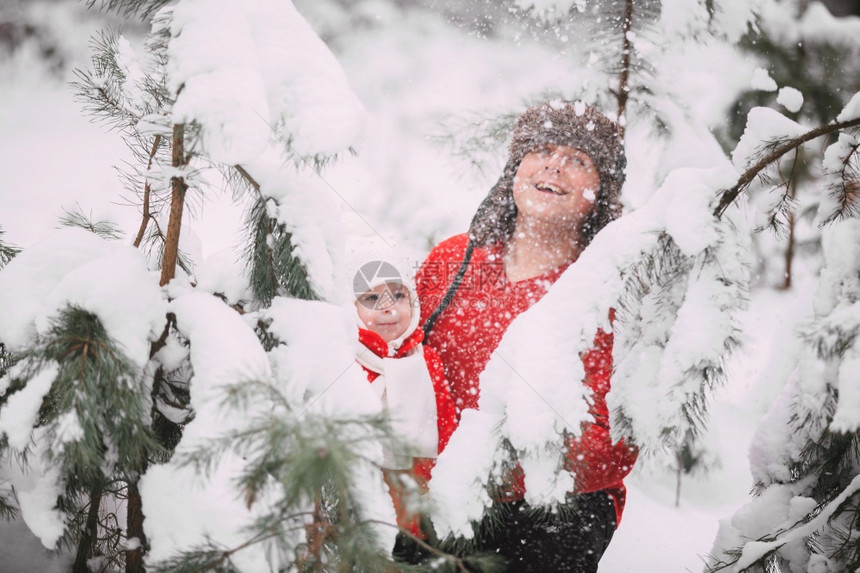 快乐的小女孩穿着红大衣父亲在冬季森林里玩雪女孩和爸一起玩快乐的小女孩和爸一起玩快乐的小女孩在冬季森林里玩雪快乐的小女孩和爸一起玩图片