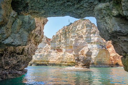 埃皮扎夫罗斯著名的海中岩石洋波尔古达的拉合岩热门夏季旅游目的地和阿尔加夫海岸线著名的滩背景