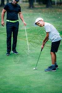 教练在教男孩打高尔夫图片