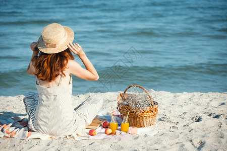 苹果篮戴着帽子的女孩和篮带着面包苹果和汁野餐背景