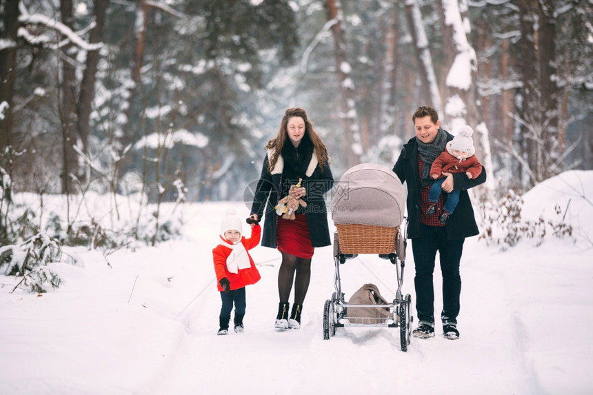夫妇两推着婴儿车带着孩子雪地合影图片
