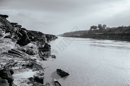 渔夫岩石地方在Mekong河边的大沙石峡崖悬边和当地Thai渔船在nuboratchniTlnd背景