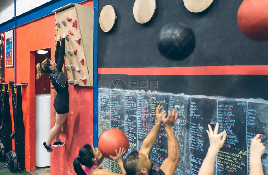 体育馆的攀爬墙壁上挂着女运动员的训练同学们在做壁球图片