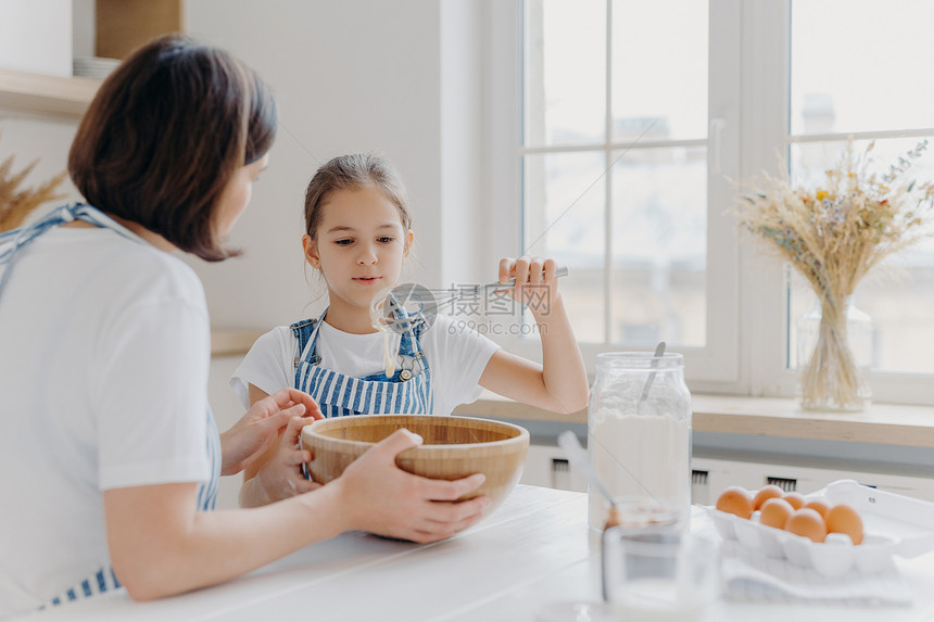 可爱女儿和妈妈一起做饭享受家庭气氛图片