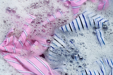 彩色衣服的顶部视图浸泡在粉末洗涤水溶解中洗澡高清图片素材