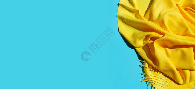 蓝色背景的黄围巾夏天带有复制空间的顶部视图图片