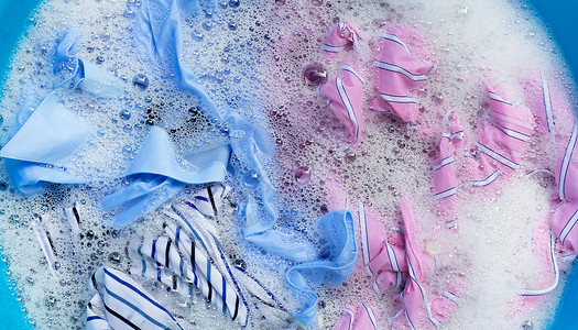 彩色衣服的顶部视图浸泡在粉末洗涤水溶解中脚高清图片素材