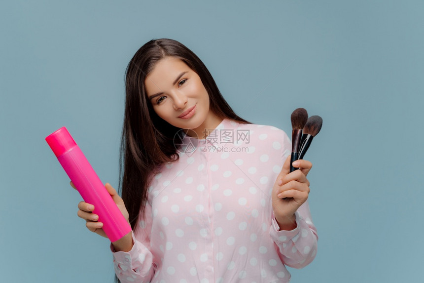 手持化妆刷工具与美发工具的女子图片