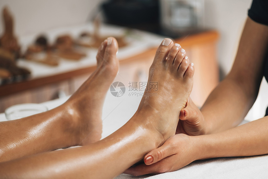 女治疗师按摩客户和rc参加健康沙龙的脚足反射按摩图片