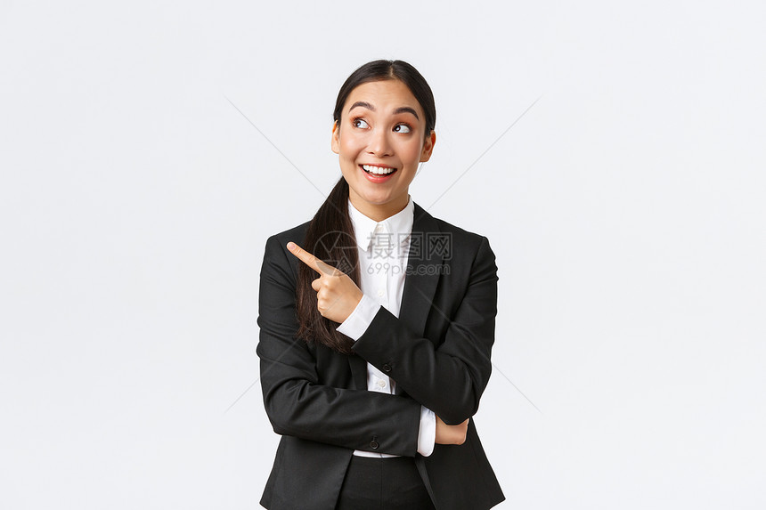 兴奋和欢乐的年轻女商人喜欢用左手指着看宣传广告站在白色背景上激动人心企业家提出伟大的建议兴奋和欢乐的年轻女商人激动心图片