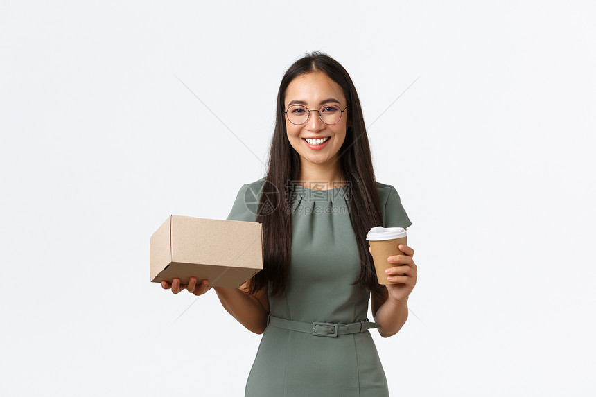 成功笑的年轻女小企业主喝外送咖啡的女商人拿着装满顾客购买的物品包装箱网上商店客户的装运包裹成功笑的年轻女小企业主喝外送咖啡的女商图片