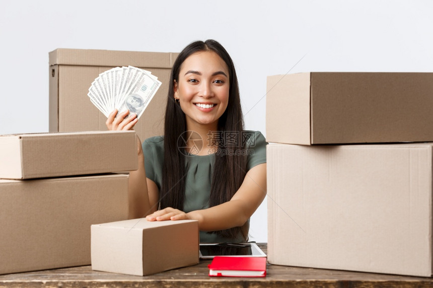 小业主创和电子商务概念自豪和快乐的亚洲女商人在网上赚钱展示现金和包装单箱船在家工作自豪和快乐的亚洲女商人在网上赚钱装箱船在家工作图片