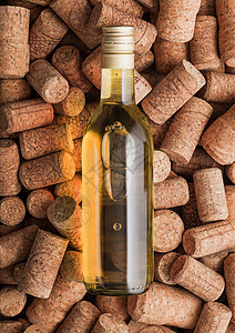 在各种葡萄酒软木背景之上的白葡萄酒瓶子宏背景图片