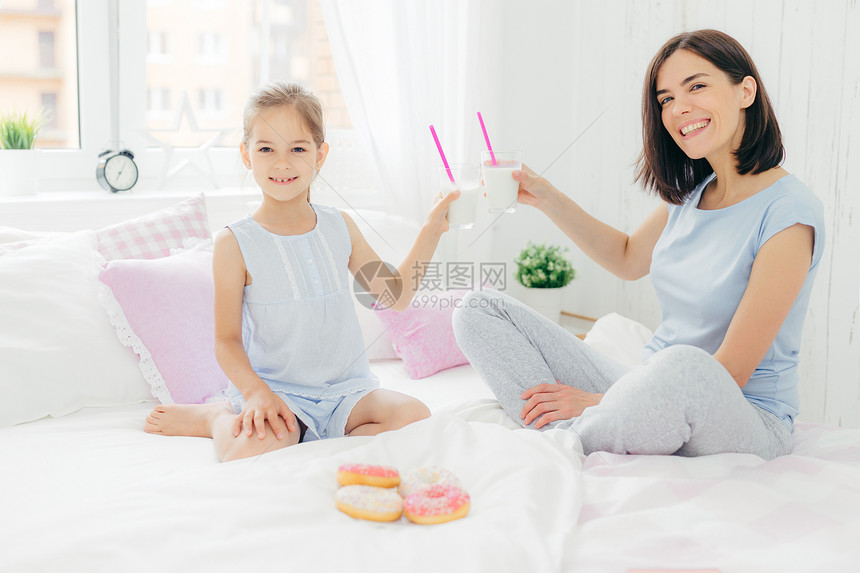 女孩与母亲一起喝着美味的奶昔图片