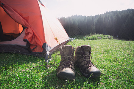 旅游者在山上徒步旅行帐篷和靴子图片