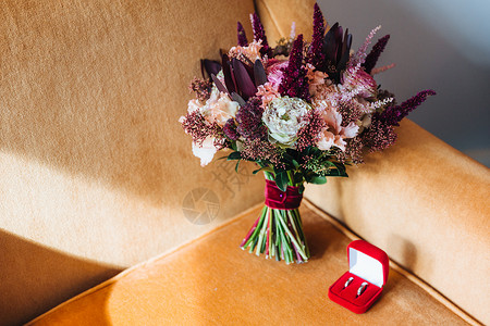 结婚戒指和用扶手椅布置的嫁妆用各种美丽的花朵布置图片