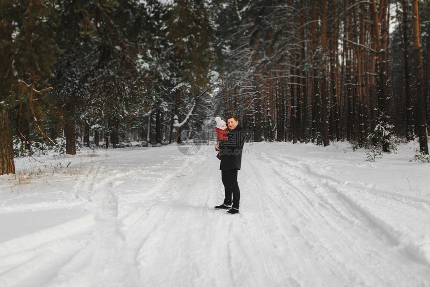 快乐的爸和小儿子在冬季雪林里玩乐的肖像图片