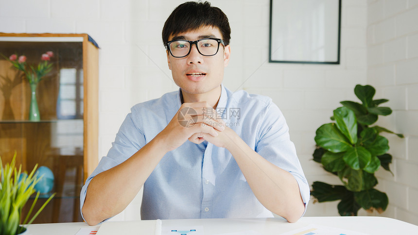 商人使用电脑与同事谈论会议计划图片