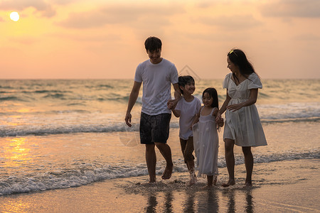 父亲妈和孩子在日落时一起海边散步旅行度假生活方式旅行假期暑概念图片