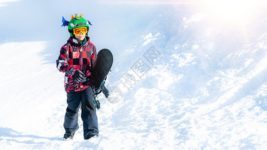 山冬渡假站的男孩与在雪板上滑图片