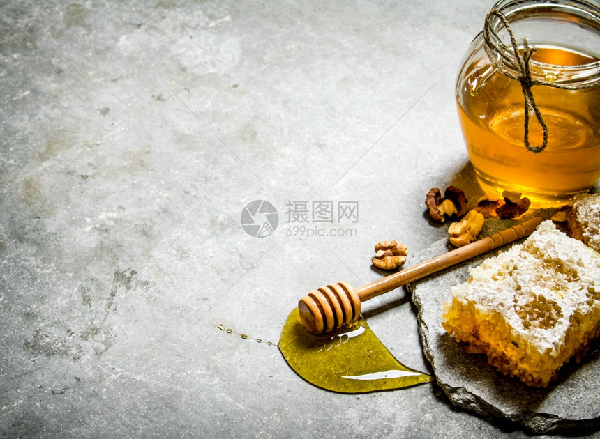 蜂蜜背景天然甜胡桃贝壳在石板上图片