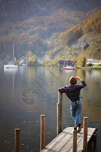 少女站在湖边的码头上和山的背景自由高清图片素材