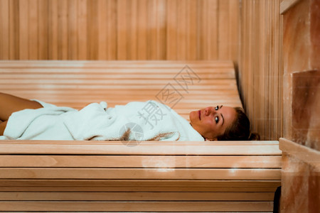 女人在盐间休息躺浴袍上坐长椅享受女人在盐洞或间图片