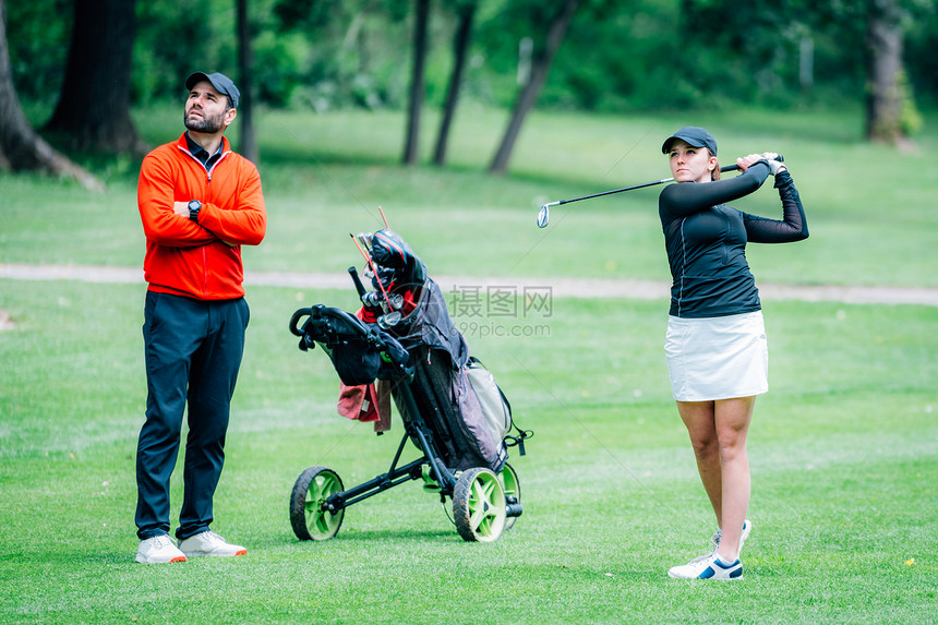 两名有高尔夫教练的年轻女士在高尔夫球场上课图片