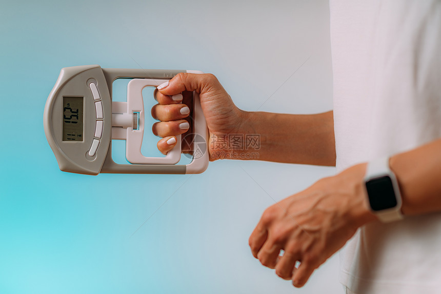 妇女拥有数字手握力计测量体图片