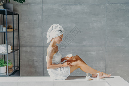 衣着浴巾笑容温柔洗完澡后皮肤保持健康在舒适的卫生间里充气背景图片