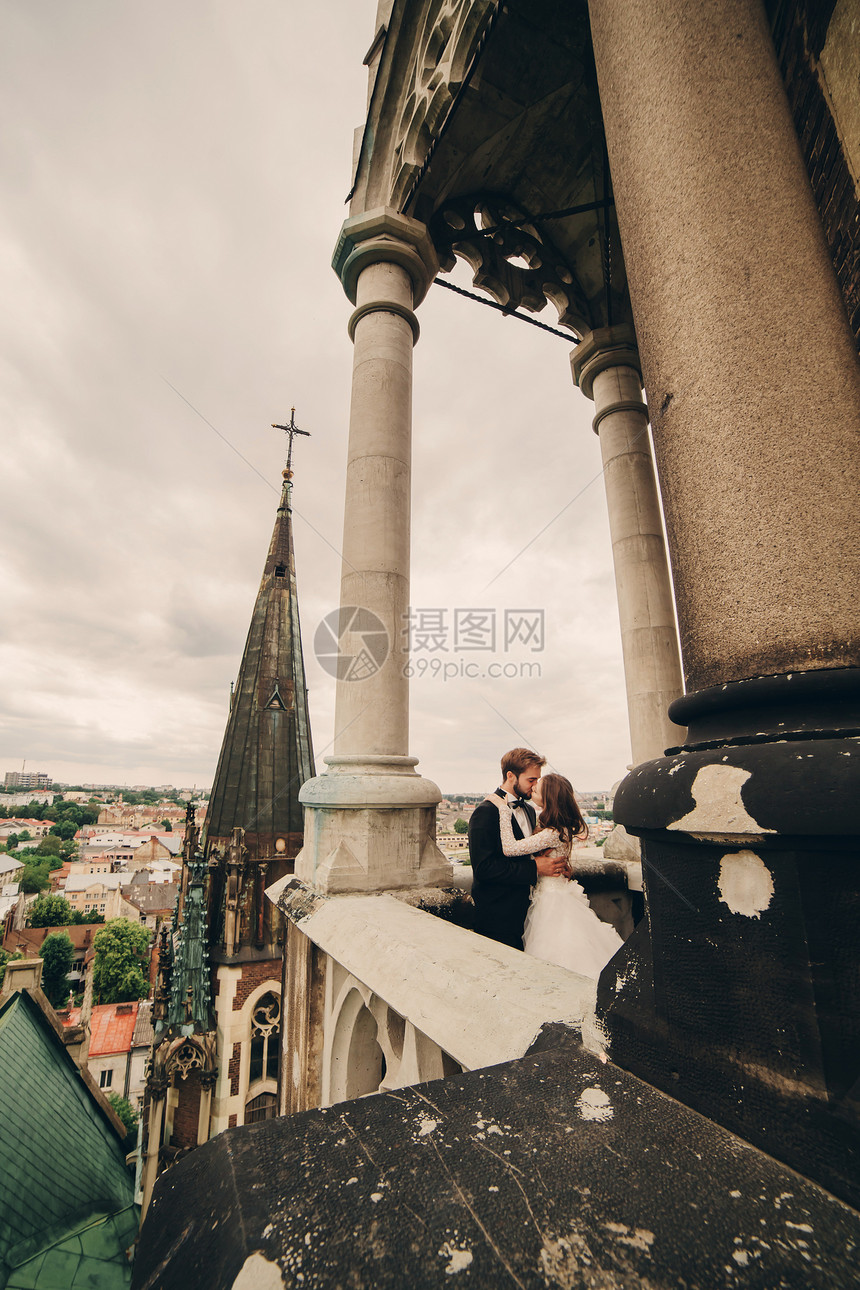 在哥特教堂阳台上接吻的夫妇图片