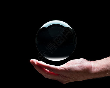 握着水晶期货或财富的高级天主教手与黑中间的球交谈以暗示在你的掌中保持未来手握着晶玻璃预测球与黑中间的玻璃预测球以方便合成背景图片