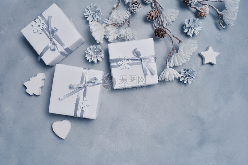 带有锥形木玩具和礼品盒的圣诞假框架带有锥形木玩具和礼品盒的边框位于灰色抽象背景的边框上为您文本留出空间带有锥形木玩具和礼品盒的模图片