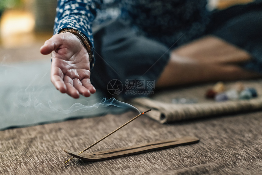 在家默思期间用烟燃香棍烧用女手露棕榈怀念的妇女每天用燃烧的香棍进行默思图片