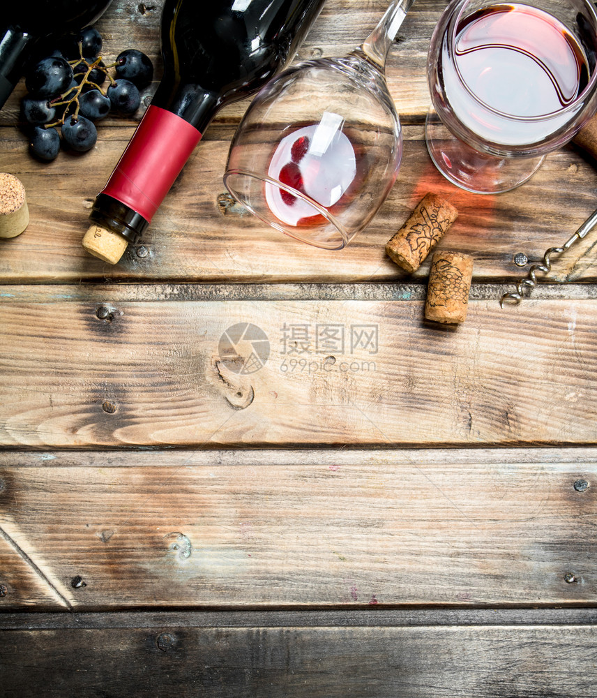 红酒在杯子里葡萄和酒瓶在木质背景上红酒在杯子里葡萄和酒瓶子图片