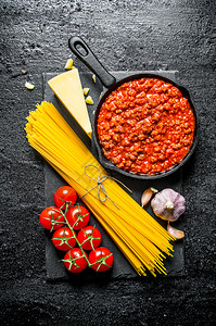 面食背景干意大利面有肉酱西红柿和大蒜黑色生锈背景西红柿和大蒜图片