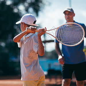 网球训练课程教官与男孩一起参加网球训练课程背景图片