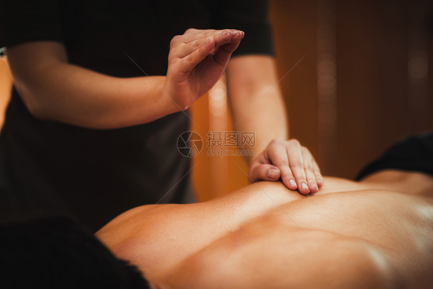 生理治疗师按摩男病人背部肌肉受伤运动害治疗图片
