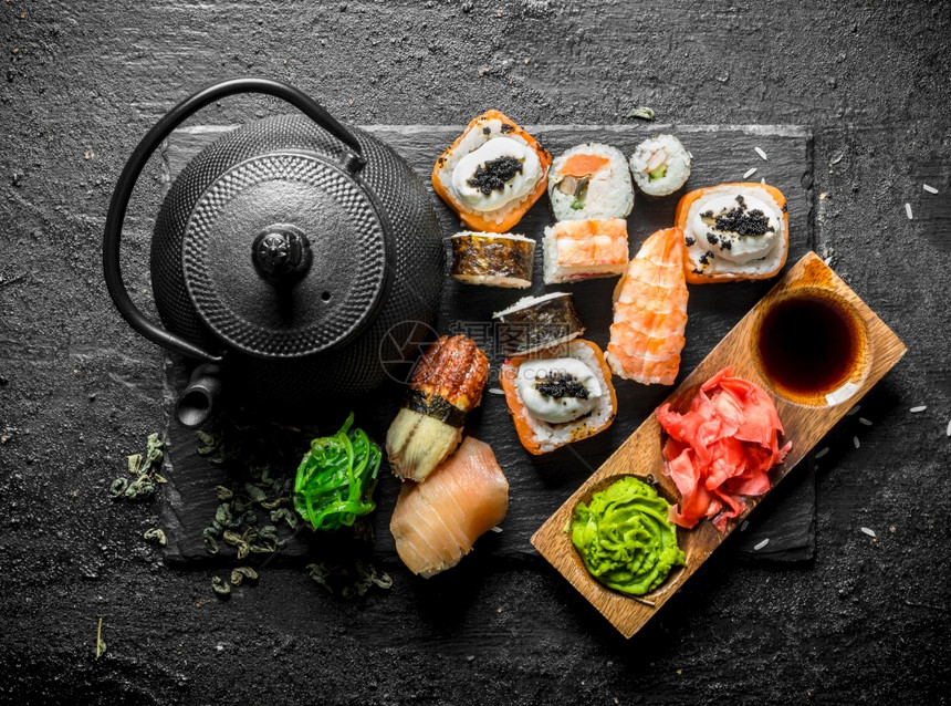 传统日本寿司卷配有绿茶黑生化背景配有绿茶图片
